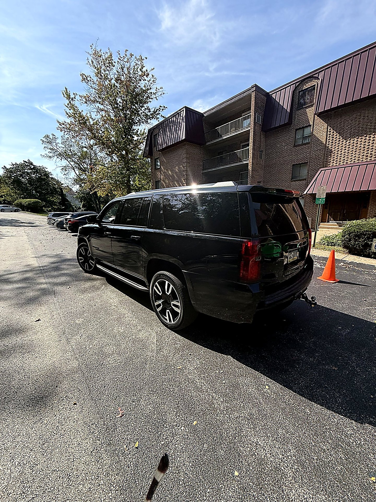 Black SUV parked on a street in front of a brick building