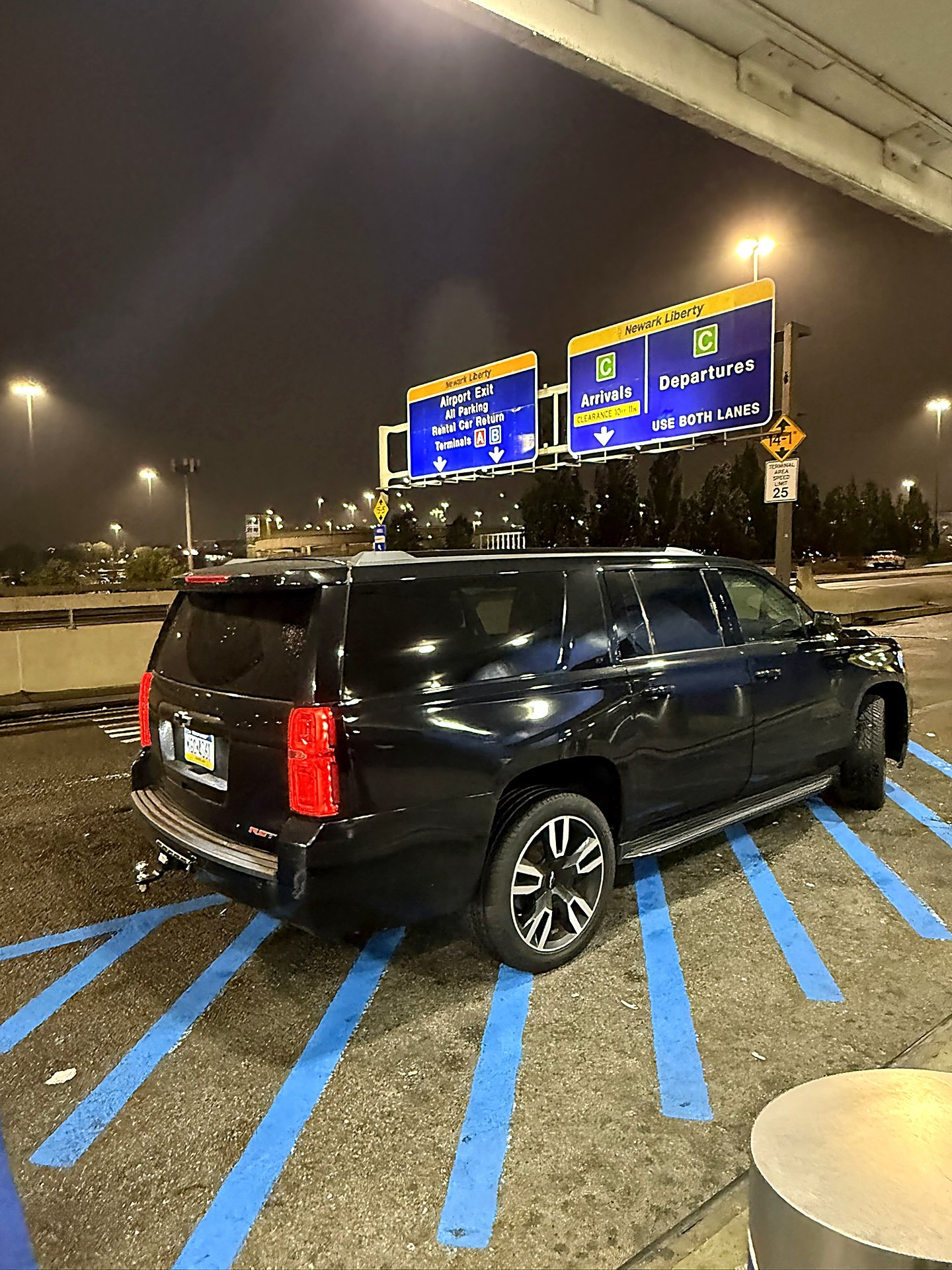 Black SUV waiting at Newark Liberty airport terminal at night