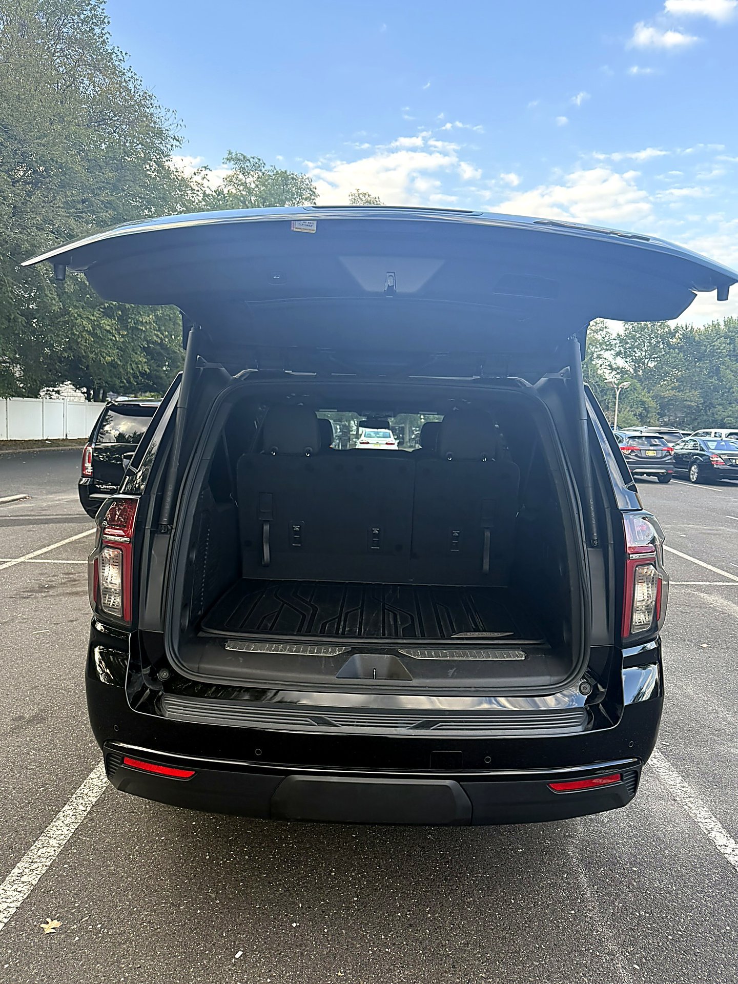 Black SUV with open trunk showing empty cargo space in a parking lot