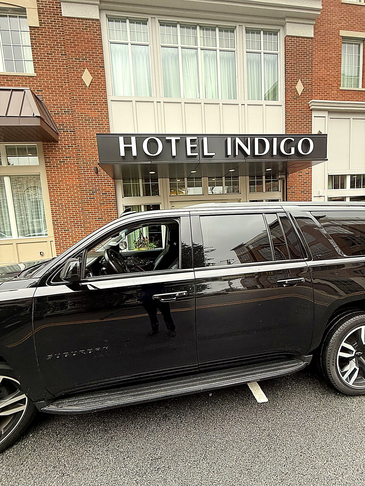 Black SUV parked in front of the Hotel Indigo entrance