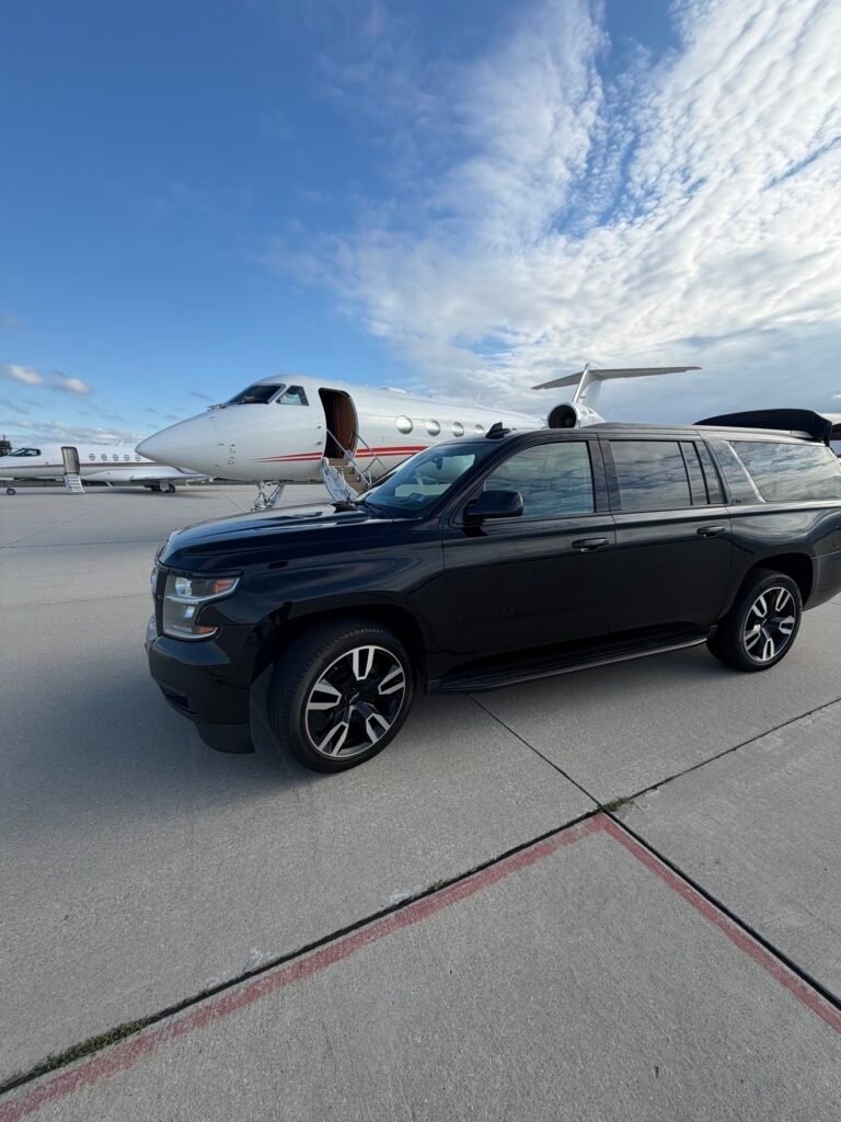 Black Chevrolet Suburban beside a private jet for private aviation and FBO airport transfers in Philadelphia.